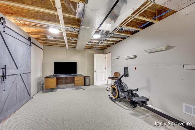 workout room featuring visible vents, carpet flooring, and a barn door