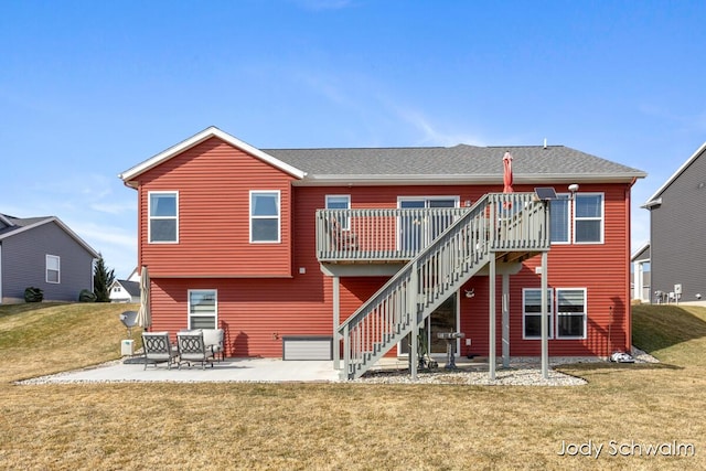 back of house featuring a patio, stairway, roof with shingles, a deck, and a lawn