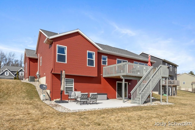 back of house with central air condition unit, stairway, a lawn, a deck, and a patio