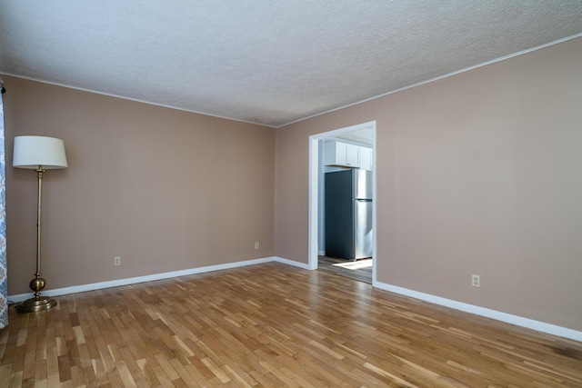 empty room featuring a textured ceiling and light wood-type flooring