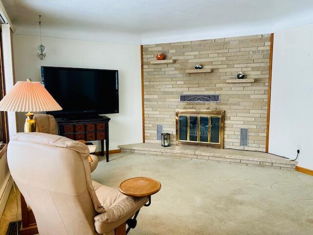 carpeted living room with a fireplace