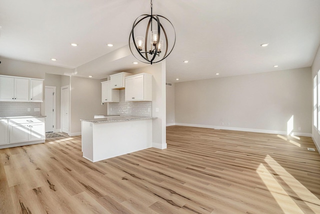 kitchen featuring light hardwood / wood-style flooring, kitchen peninsula, and white cabinets