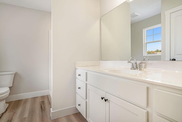 bathroom featuring hardwood / wood-style flooring, vanity, and toilet