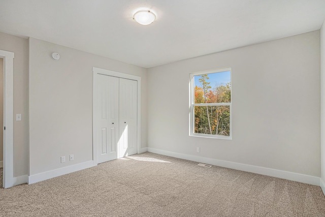 unfurnished bedroom with carpet floors and a closet