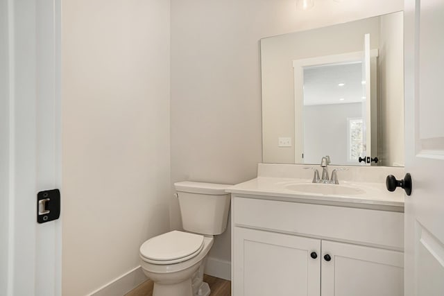 bathroom featuring vanity, toilet, and hardwood / wood-style floors