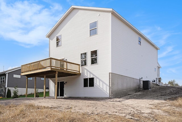 rear view of property with a wooden deck and cooling unit