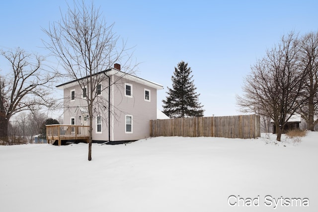 snow covered property with a deck