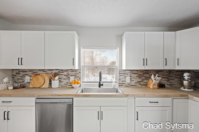 kitchen featuring sink, white cabinetry, a textured ceiling, decorative backsplash, and stainless steel dishwasher