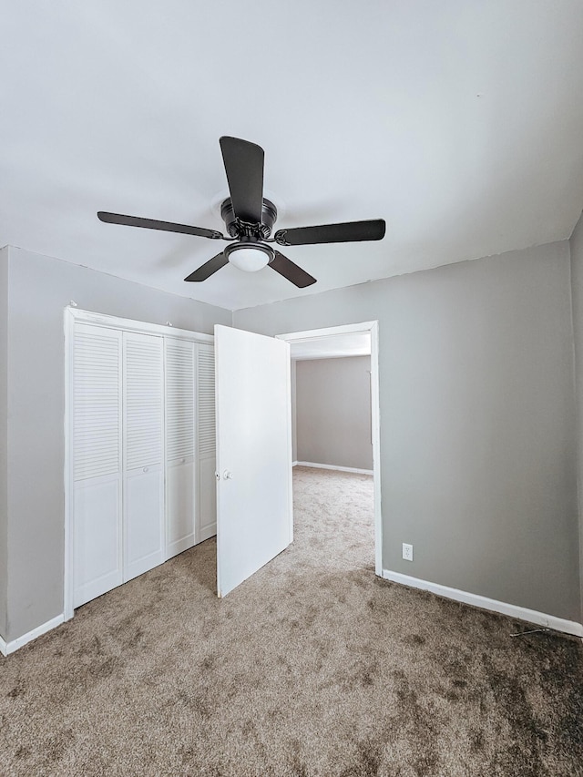 unfurnished bedroom featuring carpet flooring, ceiling fan, and a closet