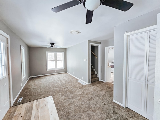 interior space with ceiling fan and light colored carpet