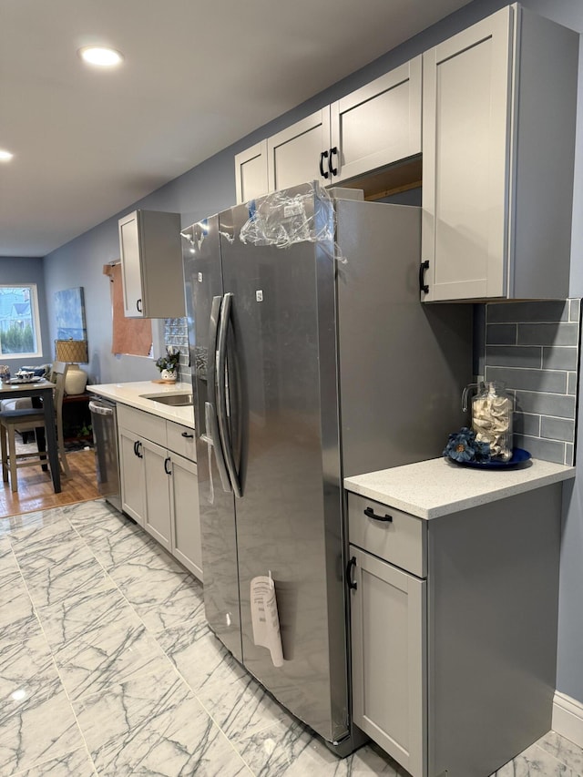 kitchen with backsplash, appliances with stainless steel finishes, and gray cabinetry