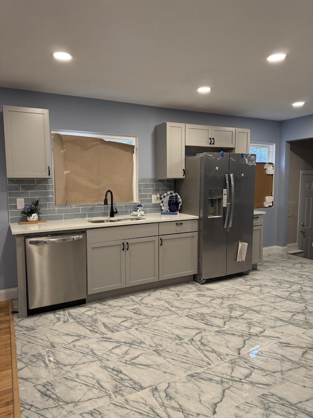 kitchen with decorative backsplash, sink, gray cabinets, and stainless steel appliances