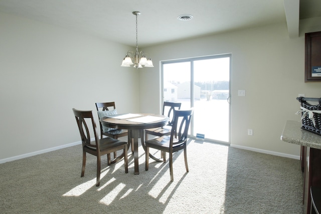 dining area featuring light carpet and an inviting chandelier