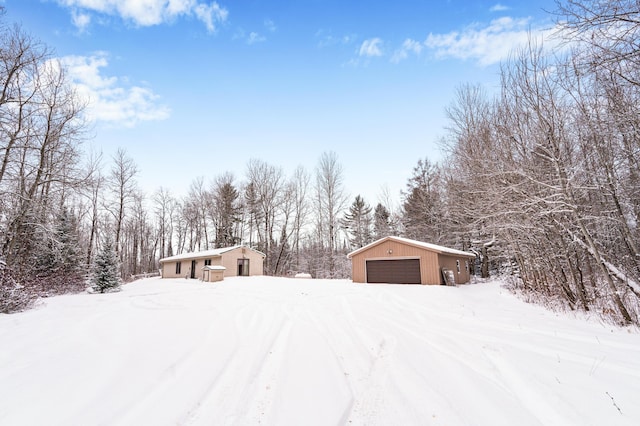 yard covered in snow with a garage and an outdoor structure