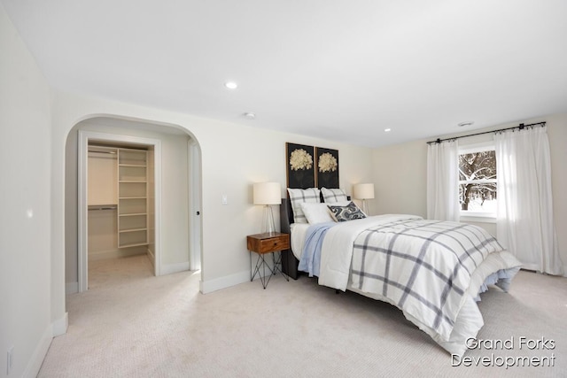 carpeted bedroom with a spacious closet and a closet