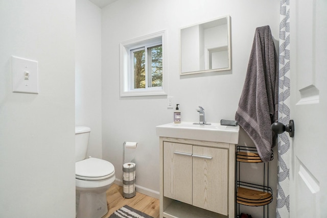 bathroom with vanity, toilet, and hardwood / wood-style floors