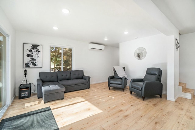 living room with an AC wall unit and light wood-type flooring