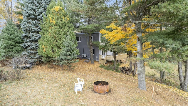 view of yard with a wooden deck and a fire pit