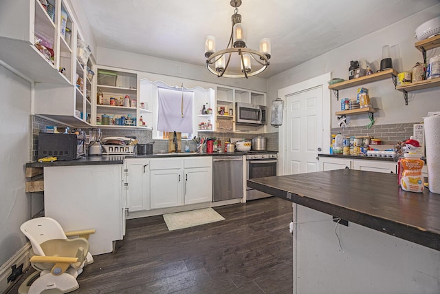 kitchen featuring sink, appliances with stainless steel finishes, white cabinetry, hanging light fixtures, and dark hardwood / wood-style floors