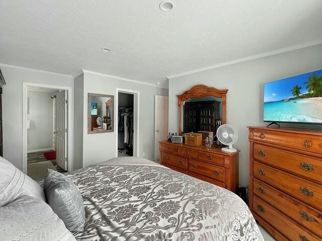 bedroom featuring a closet, a spacious closet, and ornamental molding