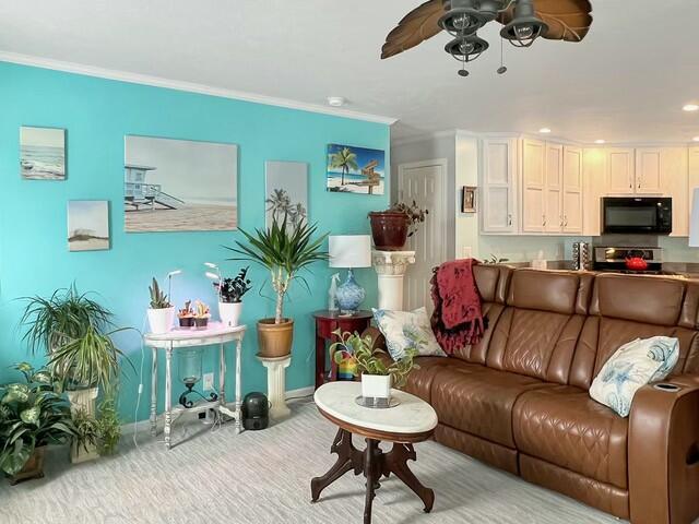 living room with ceiling fan and crown molding