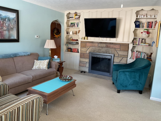 carpeted living room featuring a fireplace, built in features, and a textured ceiling