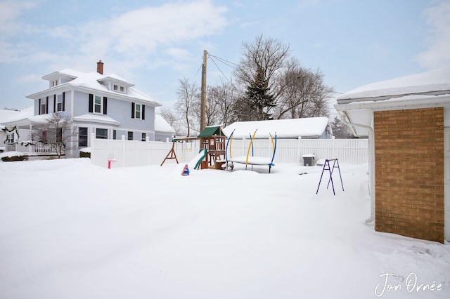 yard covered in snow with a playground