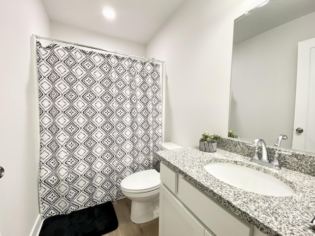 bathroom with hardwood / wood-style flooring, vanity, and toilet