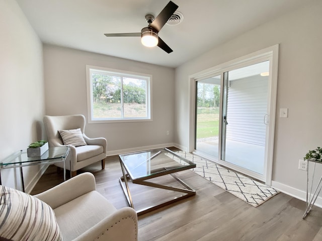 living area with ceiling fan and light hardwood / wood-style flooring