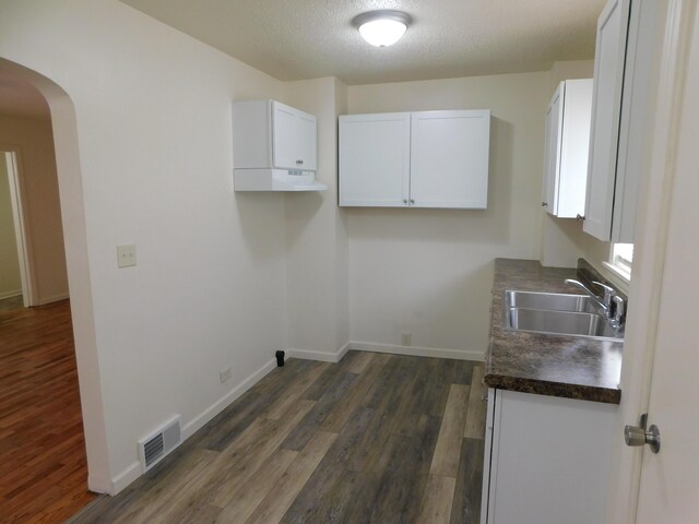 laundry room with dark hardwood / wood-style floors, sink, and a textured ceiling