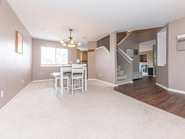 unfurnished dining area featuring hardwood / wood-style floors and an inviting chandelier