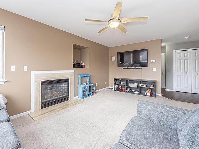 living room featuring carpet flooring and ceiling fan