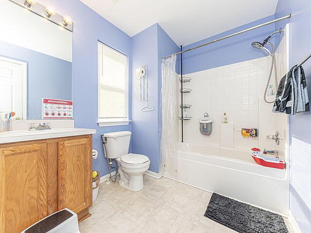 full bathroom with vanity, shower / bath combination with curtain, and toilet