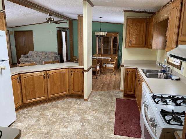 kitchen with lofted ceiling with beams, sink, hanging light fixtures, white appliances, and a textured ceiling