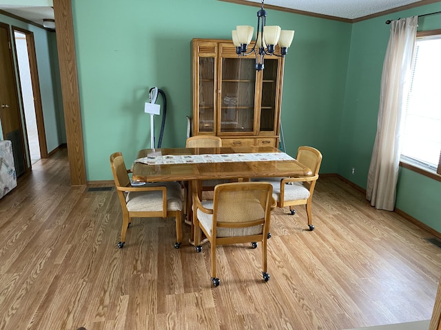 dining space with a notable chandelier, hardwood / wood-style flooring, and ornamental molding