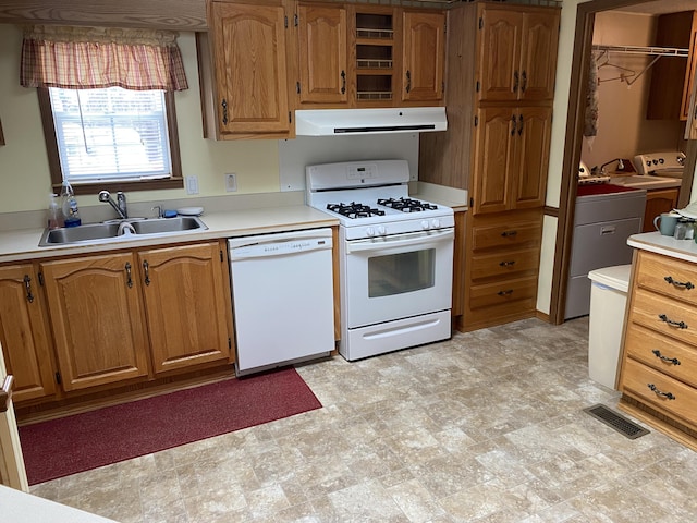 kitchen with separate washer and dryer, sink, and white appliances