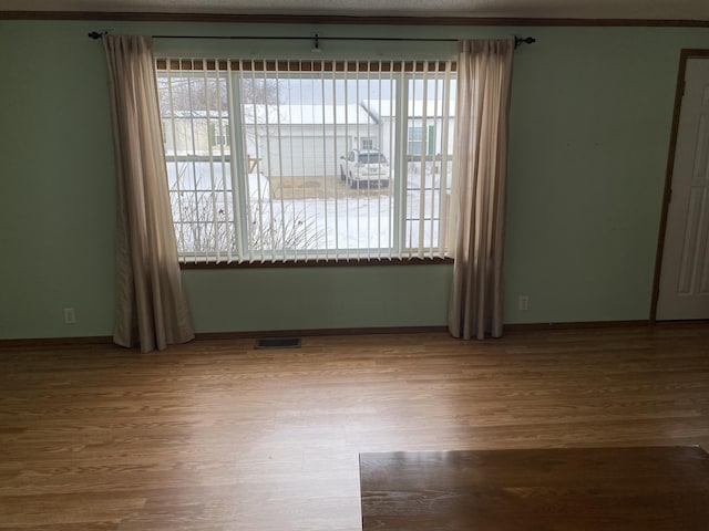 spare room with hardwood / wood-style flooring and a healthy amount of sunlight