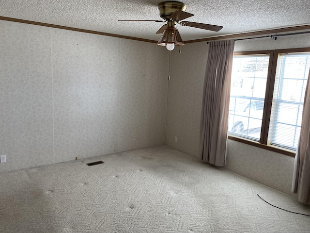 carpeted spare room featuring crown molding and ceiling fan