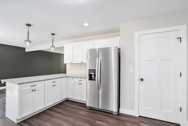 kitchen with backsplash, light stone countertops, white cabinets, stainless steel fridge with ice dispenser, and decorative light fixtures