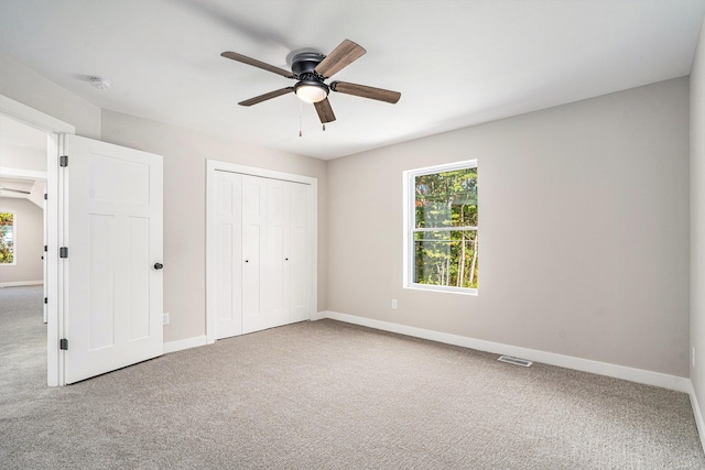 unfurnished bedroom with carpet flooring, ceiling fan, and a closet