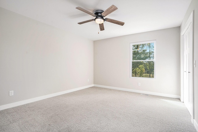 carpeted spare room featuring ceiling fan