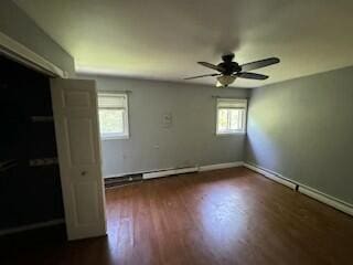 unfurnished bedroom featuring multiple windows, dark hardwood / wood-style flooring, a closet, and ceiling fan