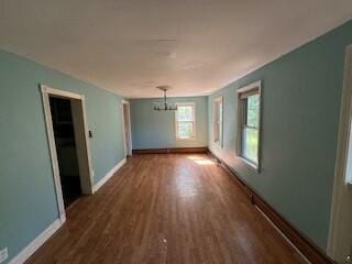 unfurnished room with dark hardwood / wood-style flooring and a chandelier