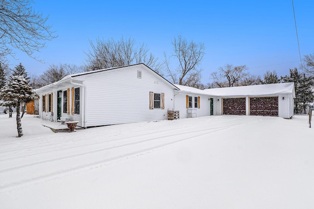 view of snow covered exterior with a garage