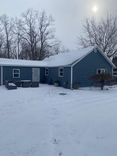 view of snow covered back of property