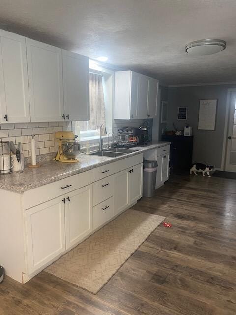 kitchen featuring white cabinetry, dark hardwood / wood-style floors, sink, and tasteful backsplash