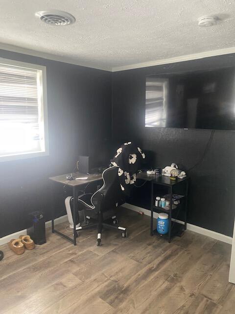 home office with hardwood / wood-style floors and a textured ceiling