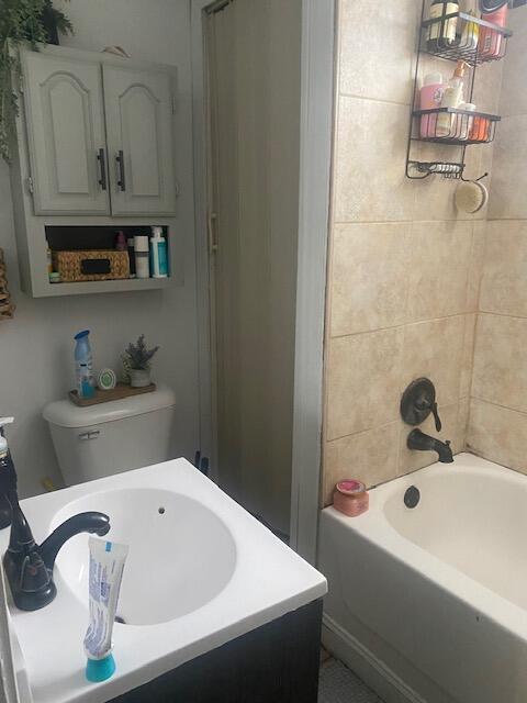 bathroom with tiled shower / bath and toilet