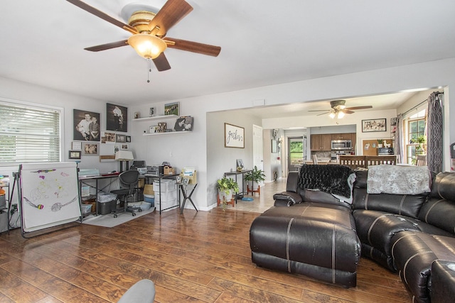 living room with ceiling fan and dark hardwood / wood-style flooring