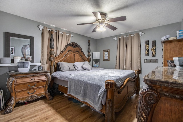 bedroom featuring a textured ceiling, light hardwood / wood-style floors, and ceiling fan